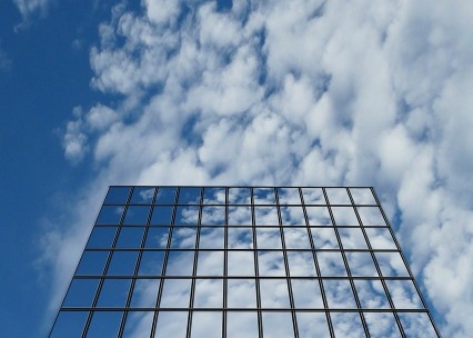 Foto di un edificio con vetrate che riflettono il cielo